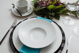 It imparts a contemporary and unique style to the table. It has plates and saucers with textured edges, subtly conical cups and ergonomic handles. 
