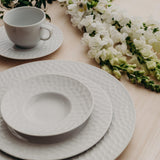 It imparts a contemporary and unique style to the table. It has plates and saucers with textured edges, subtly conical cups and ergonomic handles. 