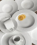 It imparts a contemporary and unique style to the table. It has plates and saucers with textured edges, subtly conical cups and ergonomic handles. 